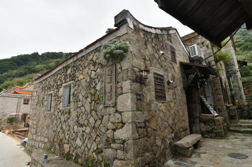 um velho edifício de pedra com uma planta sobre ele em Chinbe D.S House 2 em Beigan