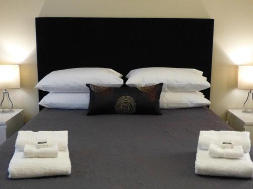 1 dormitorio con 1 cama grande con almohadas blancas en Watervale Retreat, en Watervale