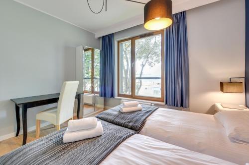 sypialnia z dużym łóżkiem i biurkiem w obiekcie Gdansk Comfort Apartments Bursztynowa w Gdańsku