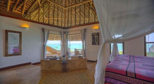 a bedroom with a bed and a large window at Matemwe Lodge in Matemwe