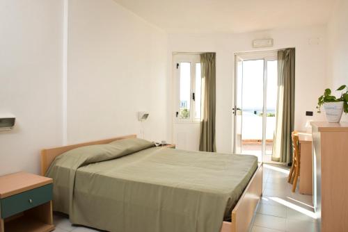 a bedroom with a bed and a door to a balcony at Corvino Resort in Monopoli