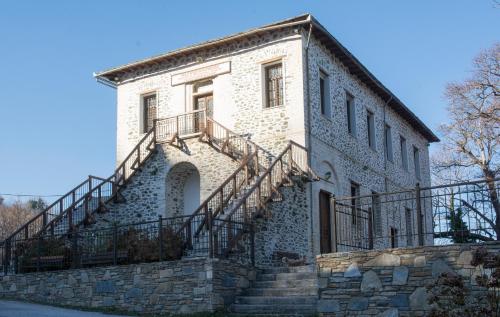 a stone building with stairs on the side of it at Red Villa's Guesthouse in Tsagarada
