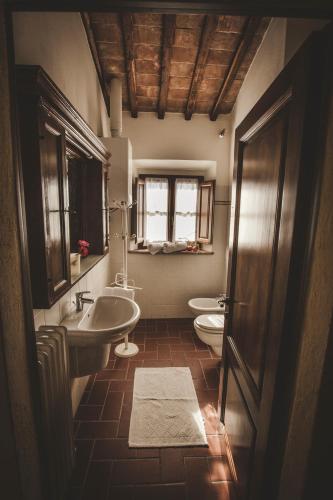 a bathroom with two sinks and a toilet and a window at Agriturismo Zampugna in Montefollonico