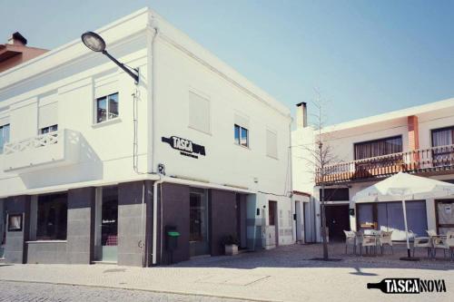 a large white building with a table in front of it at Casa do Centro in Marinha Grande