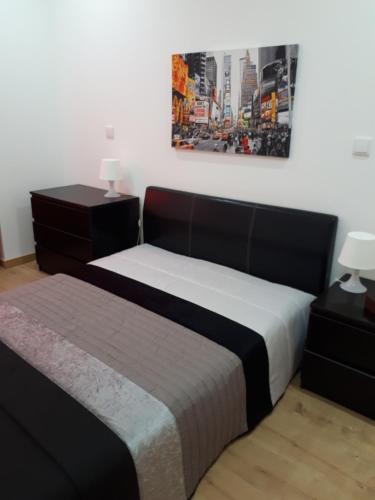 Un dormitorio con dos camas y un cuadro en la pared. en Casa do Centro, en Marinha Grande