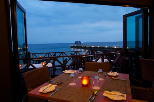 a table on a balcony with a view of the ocean at Tunamaya Beach & Spa Resort Tioman Island in Tioman Island