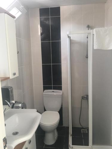 La salle de bains est pourvue de toilettes, d'un lavabo et d'une douche. dans l'établissement Teos Hotel, à Antalya