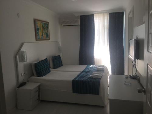 a small bedroom with a bed and a window at Teos Hotel in Antalya