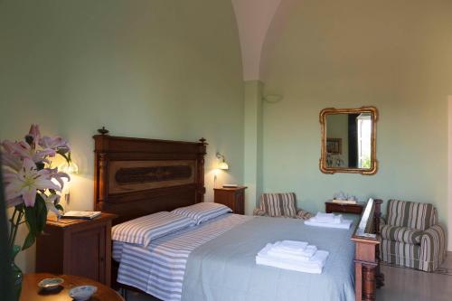Habitación de hotel con cama y espejo en Villa Urso bed&breakfast, en Monteroni di Lecce