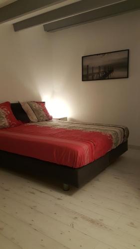 une chambre avec un lit avec une couette rouge dans l'établissement Appartement Antinea, au Cap d'Agde