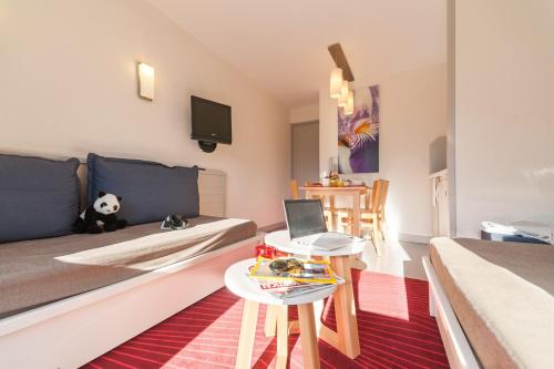 een kleine kamer met een bed en een tafel met een laptop bij Résidence Pierre & Vacances La Daille in Val dʼIsère