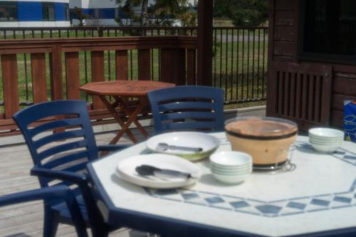 a table with chairs and plates and a bowl on it at Sakura Garden in Otaru