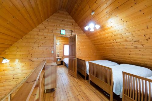 a bedroom with two beds in a wooden cabin at Sakura Garden in Otaru