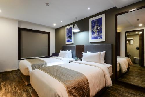 a hotel room with three beds in a room at Howard Johnson by Wyndham, Kolkata Airport in Kolkata
