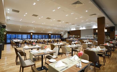 a restaurant with tables and chairs in a room at Radisson Blu Hotel Ankara Cankaya in Ankara