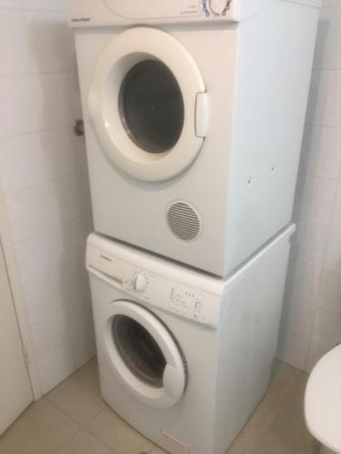 a washer and dryer in a bathroom at Grande Esplanade Studio - New bathroom in Sydney