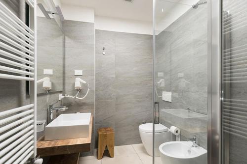 a bathroom with a sink and a toilet and a tub at B&B Il Palazzotto di Luca Luxury Suites in Lecce