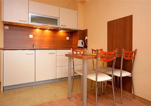 cocina con mesa, sillas y fregadero en Apartament Zdrojowa u Heleny en Świnoujście