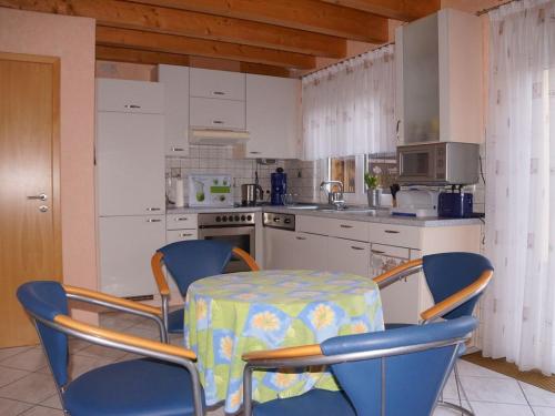 a kitchen with a table and chairs and a kitchen with a stove at Ferienhaus An der Schlossmauer in Oberschwarzach