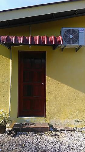 a house with a brown door at NUE Guesthouse in Kota Bharu