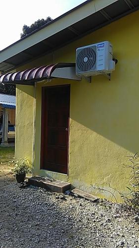 a small house with a door and a air conditioner at NUE Guesthouse in Kota Bharu