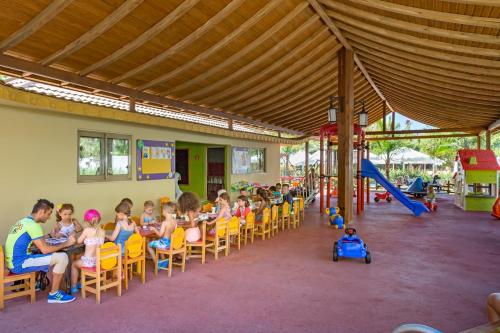 eine Gruppe Kinder, die auf einem Spielplatz auf Stühlen sitzen in der Unterkunft Royal Dragon Hotel in Side