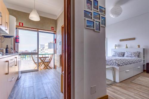 1 dormitorio con 1 cama y cocina con balcón en Avenida & Mercado by Home Sweet Home Aveiro, en Aveiro