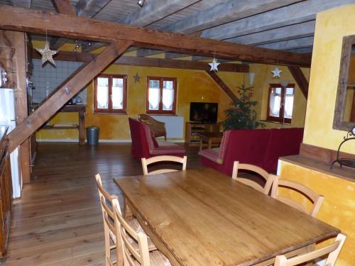 une salle à manger avec une table et des chaises en bois dans l'établissement Gites Les Petits Tisserands, à Epfig