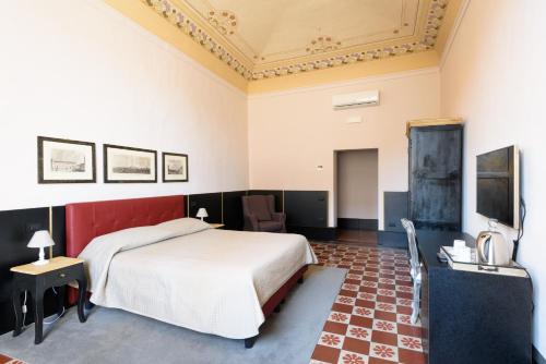 a bedroom with a bed and a desk and a tv at La Terrazza Sul Campo-Rooms Only in Siena