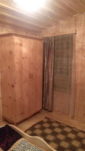 a room with wood paneled walls and a window at Ecohouse Svaneti in Mestia