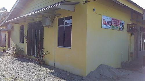 a yellow building with a sign on the side of it at NUE Guesthouse in Kota Bharu