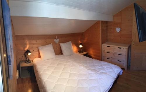 レ・デュー・アルプにあるOdalys Chalet Le Marmottonのベッドルーム(大きな白いベッド1台、ランプ2つ付)