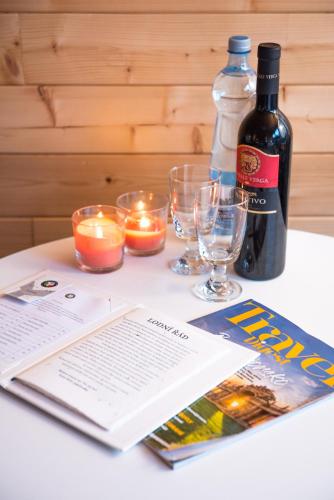 a bottle of wine and candles and a book on a table at Hausboaty Ypsilon Golf Liberec in Fojtka
