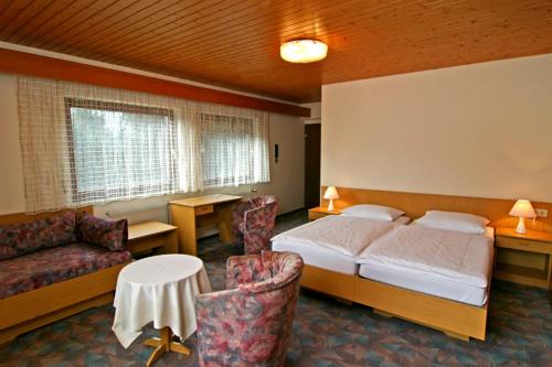 ein Schlafzimmer mit einem Bett, einem Sofa und einem Tisch in der Unterkunft Gästehaus Galant in Esslingen