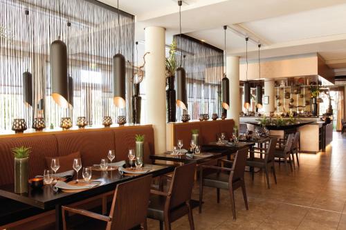 a restaurant with tables and chairs and a bar at A-ROSA Sylt in List