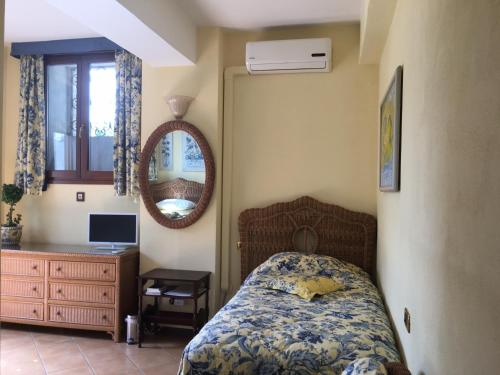 Villa Castiglioni Apartment في لاليو: غرفة نوم بسرير ومرآة وخزانة