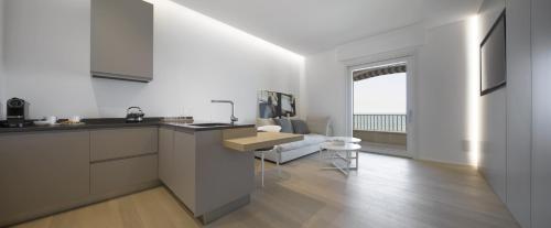 a kitchen with white cabinets and a table at Luxury Suites Collection - Milano 33 in Riccione