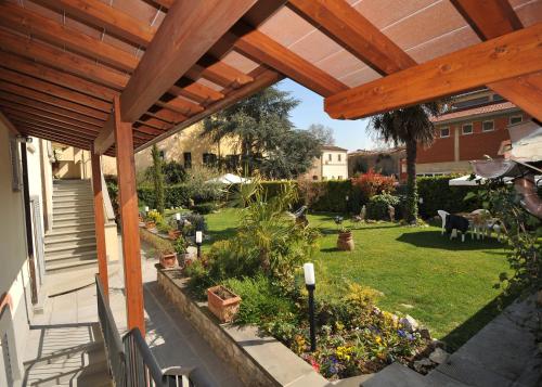 a patio with a wooden pergola and a garden at Residence Le Gagli arde in Arezzo