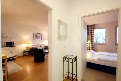 ビンツにあるVilla Maria by Rujanaのベッド1台とリビングルームが備わる客室です。