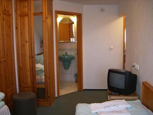 メゼーケヴェシュトにあるNapfürdő Vendégházのベッド、テレビ、バスルームが備わる客室です。