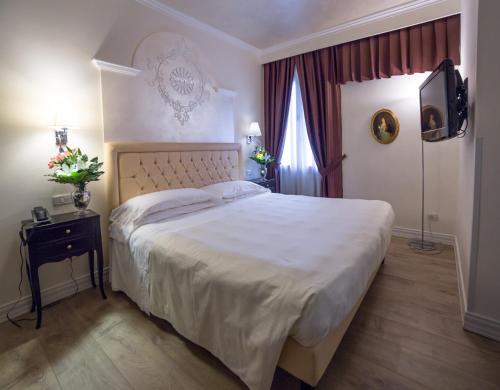 a bedroom with a large bed and a television at Hotel Patavium in Padova