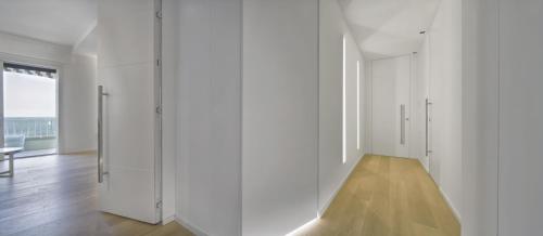 a white room with white cabinets and a wooden floor at Luxury Suites Collection - Milano 33 in Riccione
