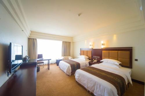 a hotel room with two beds and a flat screen tv at Ramada Chengdu North in Chengdu