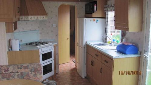 a kitchen with a white refrigerator and a sink at Hemsby Beach Sandsgate 11 in Hemsby