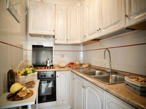 eine Küche mit weißen Schränken und einer Spüle in der Unterkunft Trulli di nonna Palma in Locorotondo