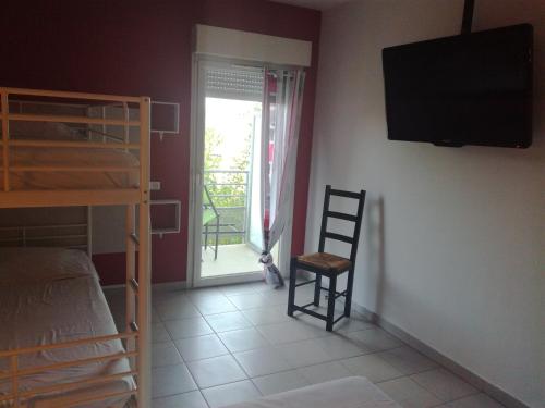 a bedroom with a bunk bed and a television on a wall at Fasthotel Montpellier Baillargues in Baillargues