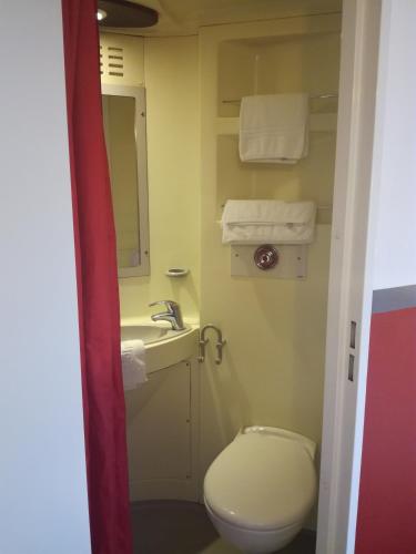 a bathroom with a toilet and a sink and a mirror at Fasthotel Montpellier Baillargues in Baillargues