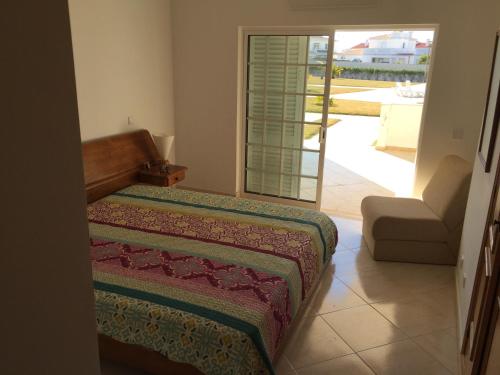 a bedroom with a bed and a view of a patio at Moradia Galé in Guia