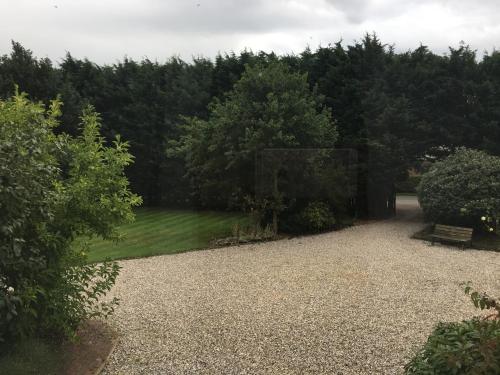 a park with a bench and a field of grass at Private luxury retreat in Sible Hedingham
