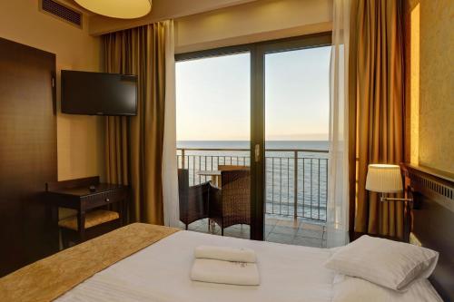 a hotel room with a bed and a balcony at Hotel Lambert Medical Spa in Ustronie Morskie